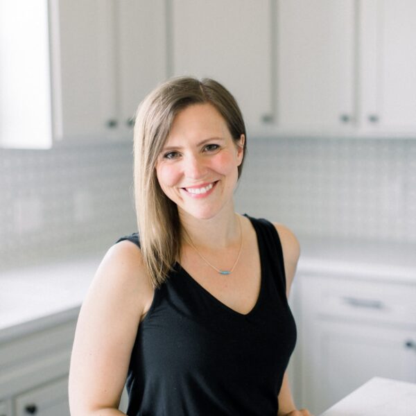 CEO, Erin Jensen, standing next to a kitchen island with an iced tea.